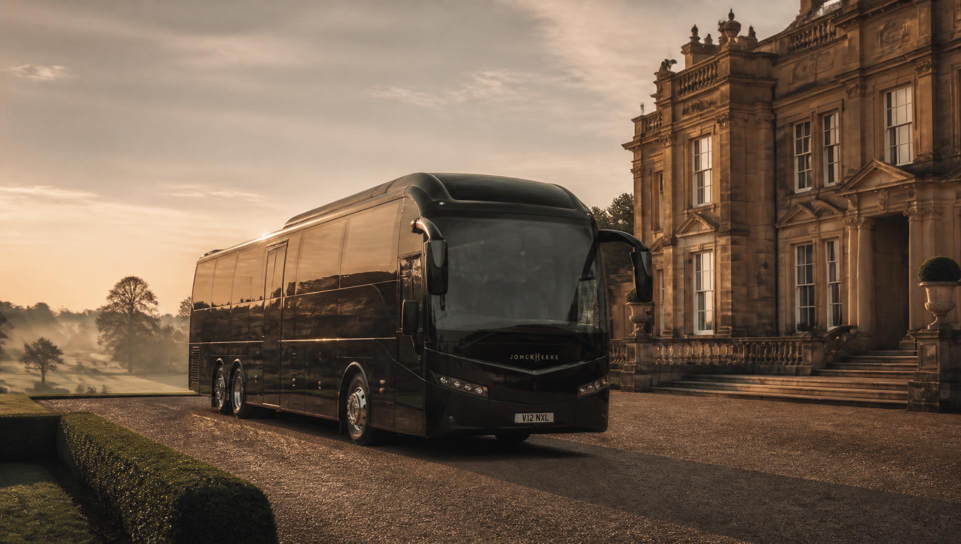 An executive coach arriving at a British countryside estate at golden hour